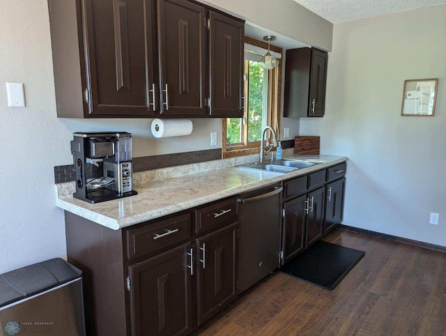 kitchen with hanging light fixtures, sink, a textured ceiling, dark wood-type flooring, and dishwasher