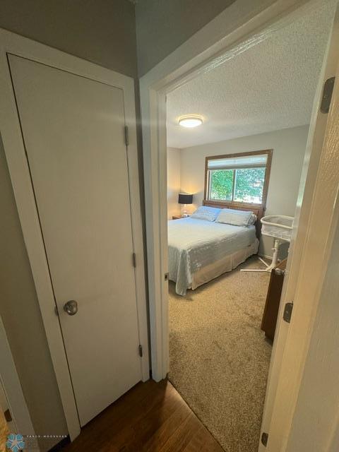 unfurnished bedroom featuring a textured ceiling and dark hardwood / wood-style floors