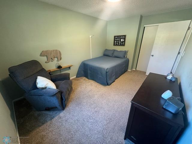 bedroom featuring a closet, carpet, and a textured ceiling