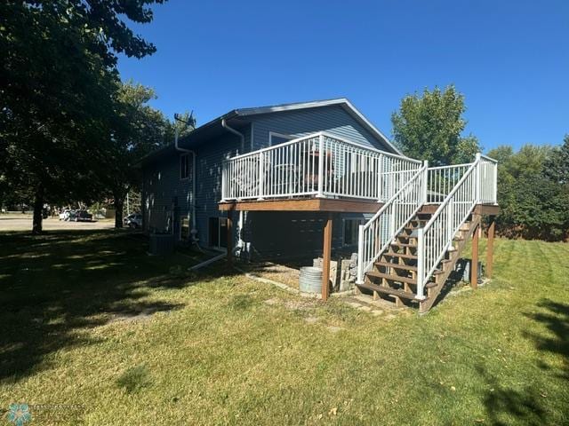 rear view of property with a deck and a yard