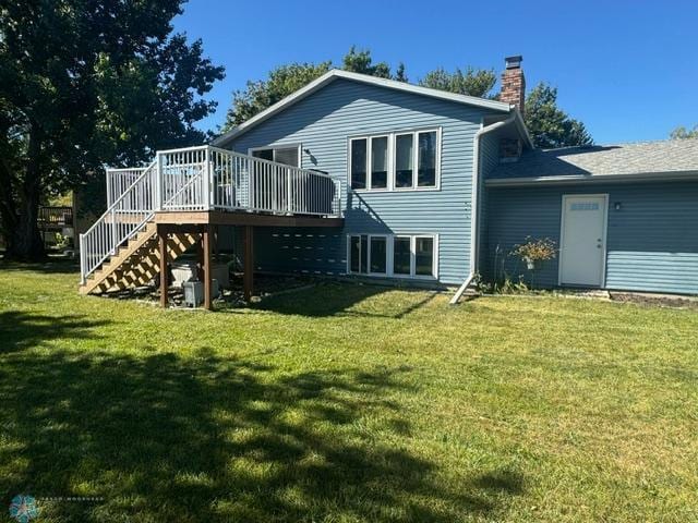 back of house with a deck and a yard