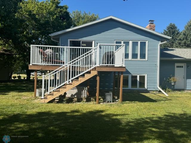 back of house featuring a wooden deck and a lawn