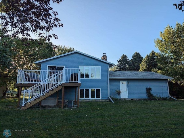 rear view of house featuring a yard and a wooden deck