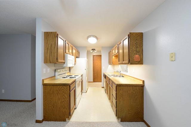 kitchen with light colored carpet, sink, and white appliances