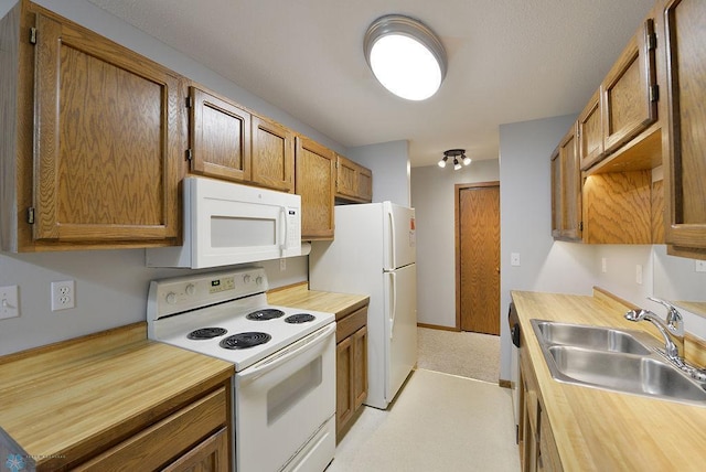 kitchen featuring white appliances, sink, and light carpet