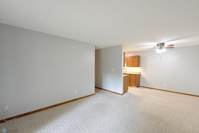 spare room featuring light carpet and ceiling fan