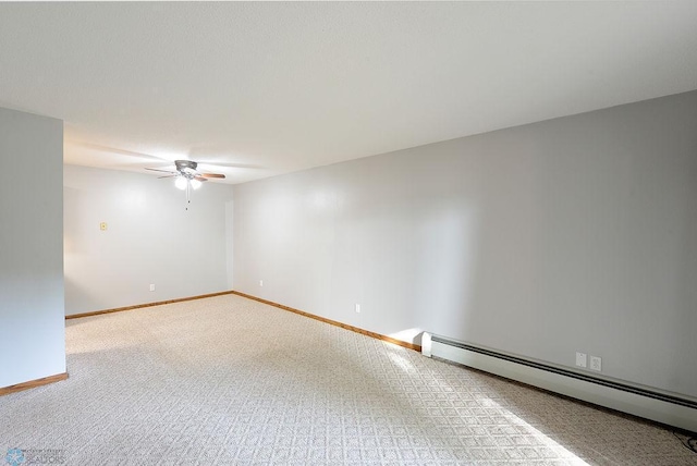 carpeted spare room featuring baseboard heating and ceiling fan