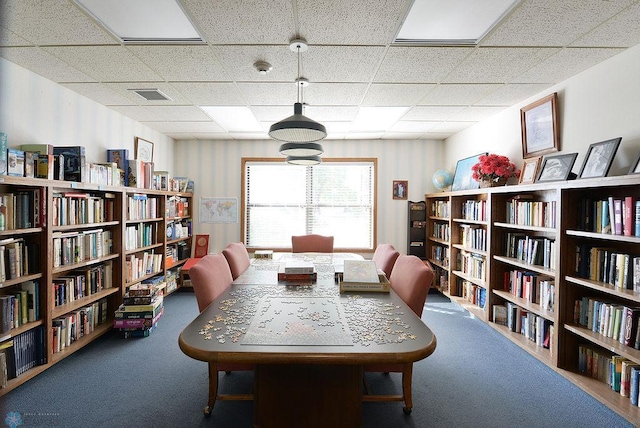 interior space featuring a drop ceiling and carpet