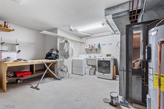 basement featuring a textured ceiling, water heater, sink, and washer and dryer