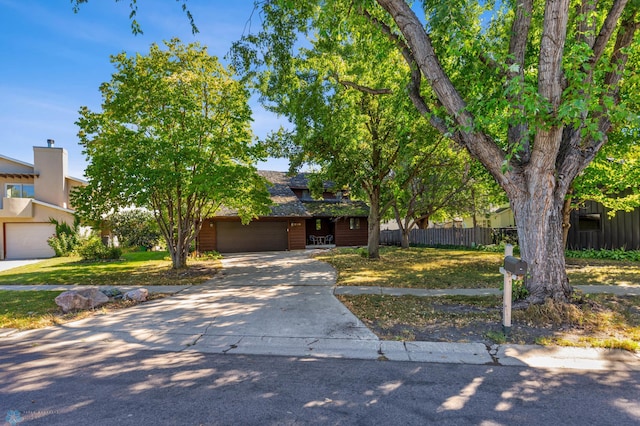 obstructed view of property featuring a garage and a front lawn