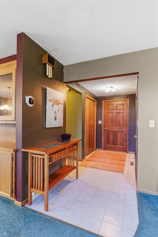 entrance foyer with light carpet and a textured ceiling