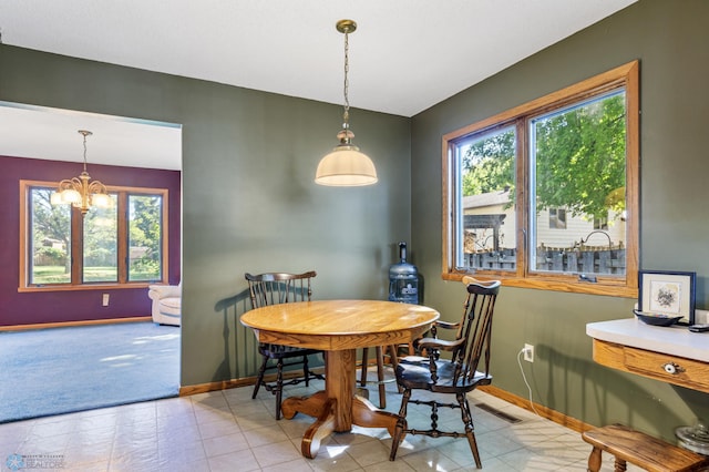 carpeted dining area featuring a notable chandelier