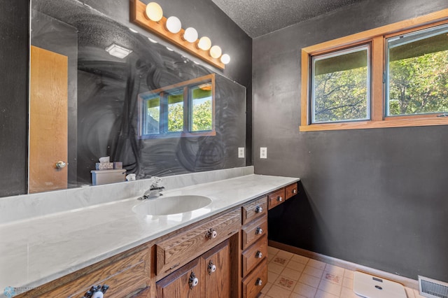 bathroom featuring a textured ceiling, vanity, toilet, and plenty of natural light