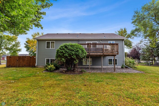 rear view of property featuring a lawn and a deck