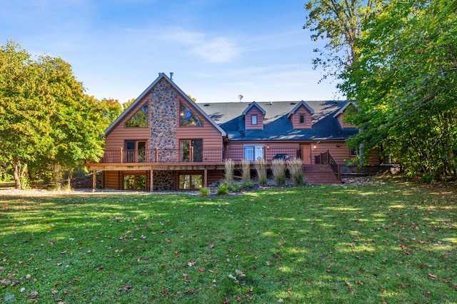 back of property featuring a wooden deck and a yard