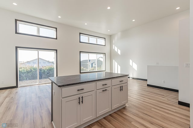 kitchen with a healthy amount of sunlight, light hardwood / wood-style floors, and white cabinetry