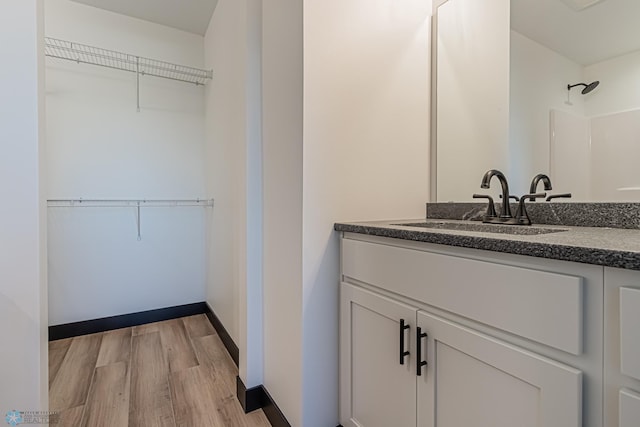 bathroom featuring walk in shower, hardwood / wood-style flooring, and vanity