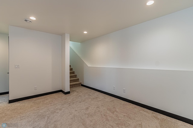 unfurnished room with light colored carpet and vaulted ceiling