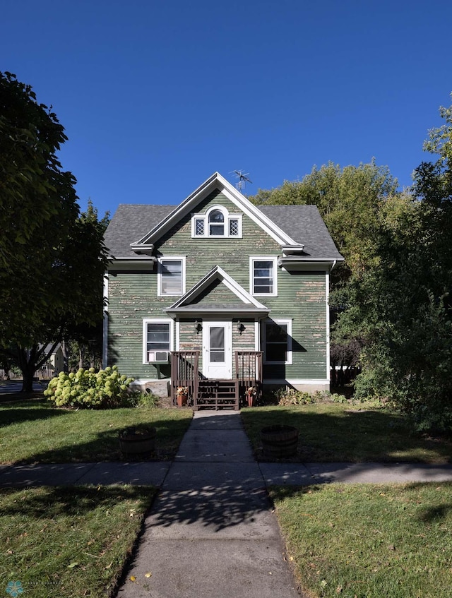 view of front facade with cooling unit and a front lawn