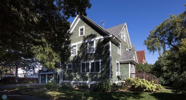 view of front of house featuring cooling unit, a deck, and a front lawn