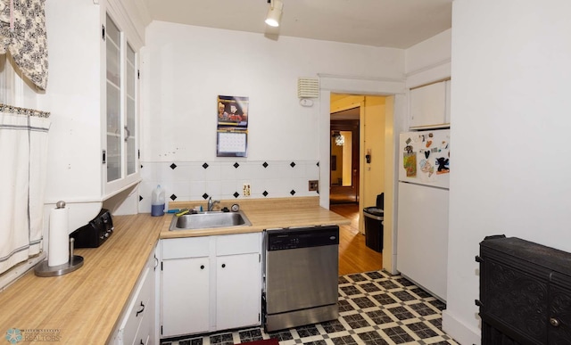 kitchen with white refrigerator, dark wood-type flooring, sink, white cabinetry, and stainless steel dishwasher