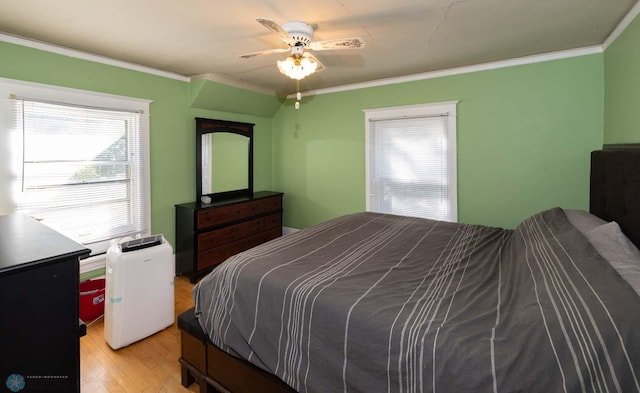 bedroom featuring crown molding, ceiling fan, and light hardwood / wood-style flooring