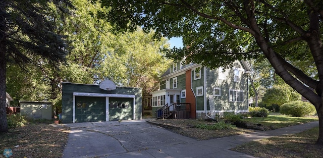 view of front of home featuring a garage and an outbuilding