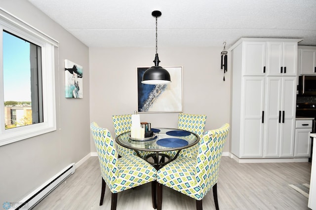 dining space with a baseboard radiator and light hardwood / wood-style flooring