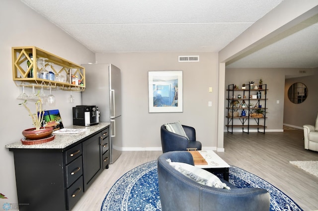 interior space featuring a textured ceiling and light hardwood / wood-style flooring