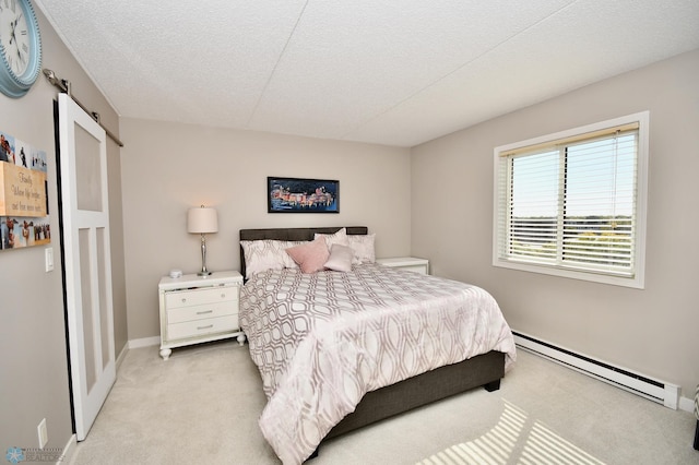 carpeted bedroom with a textured ceiling and a baseboard heating unit