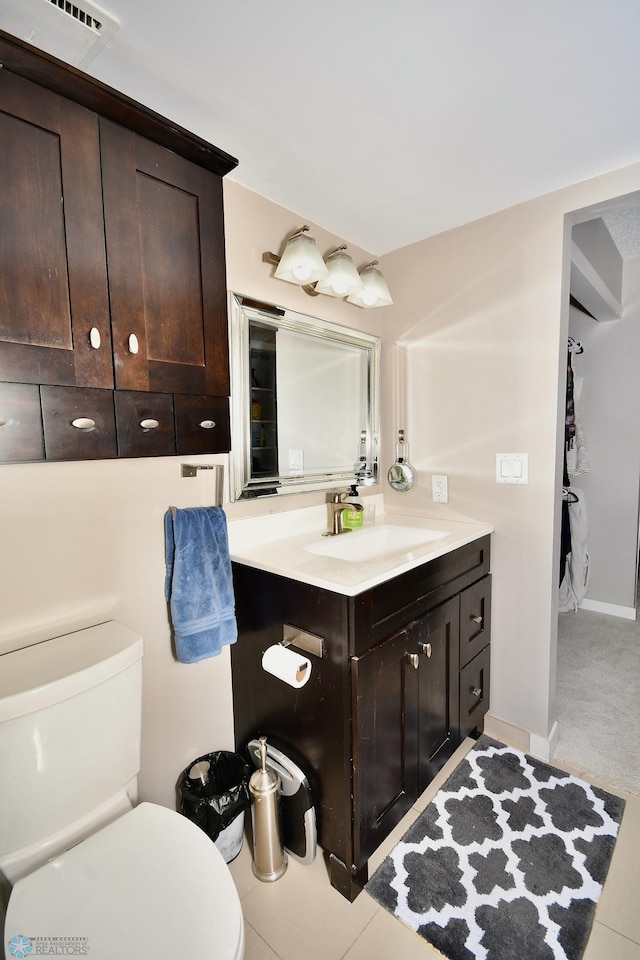 bathroom featuring tile patterned flooring, vanity, and toilet