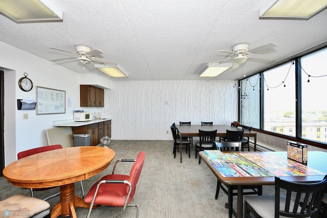 carpeted dining area featuring ceiling fan, a textured ceiling, and baseboard heating