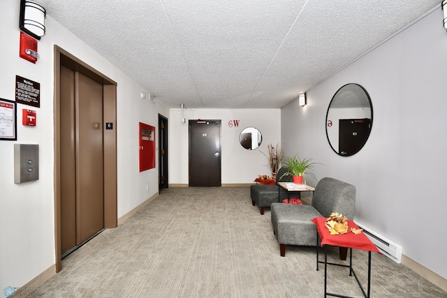 corridor with a textured ceiling, light carpet, baseboard heating, and elevator