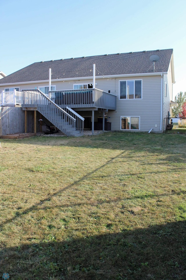 back of property featuring a wooden deck and a lawn