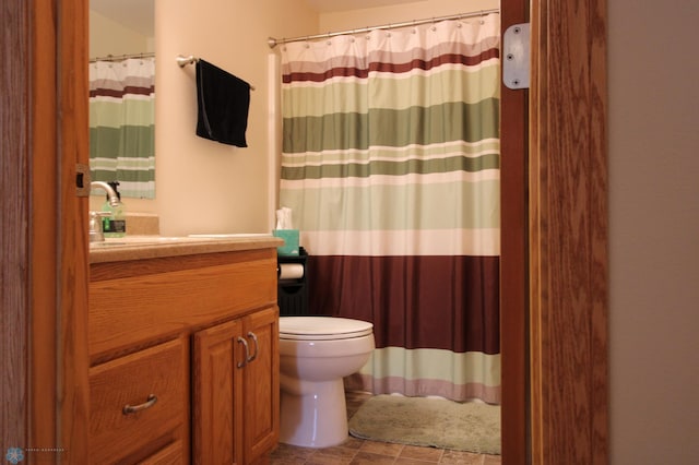 bathroom with curtained shower, vanity, and toilet