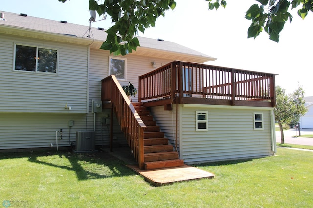 rear view of house with a lawn, a wooden deck, and central AC unit