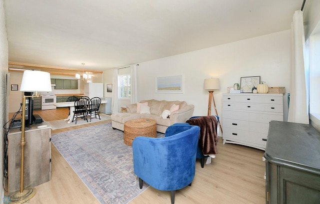 living room with light hardwood / wood-style floors and a chandelier