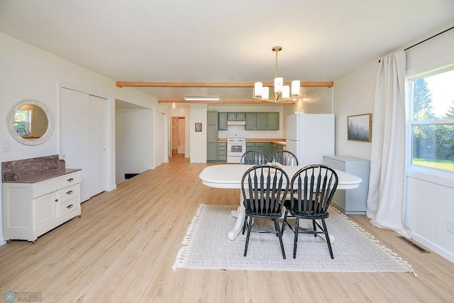 dining area featuring an inviting chandelier and light hardwood / wood-style flooring