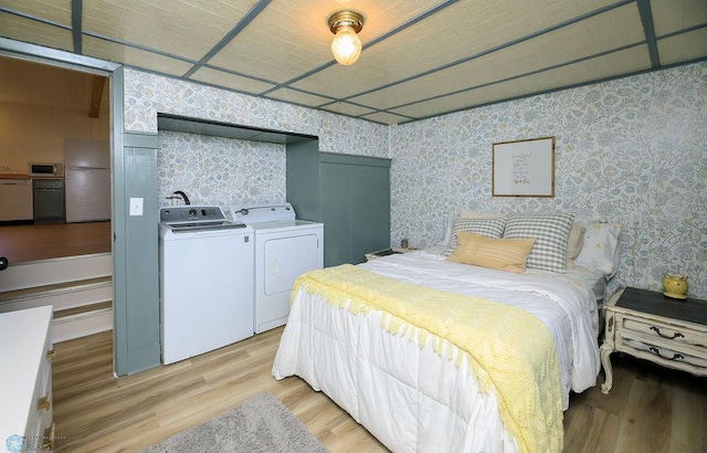 bedroom with light wood-type flooring, white fridge, and washer and dryer