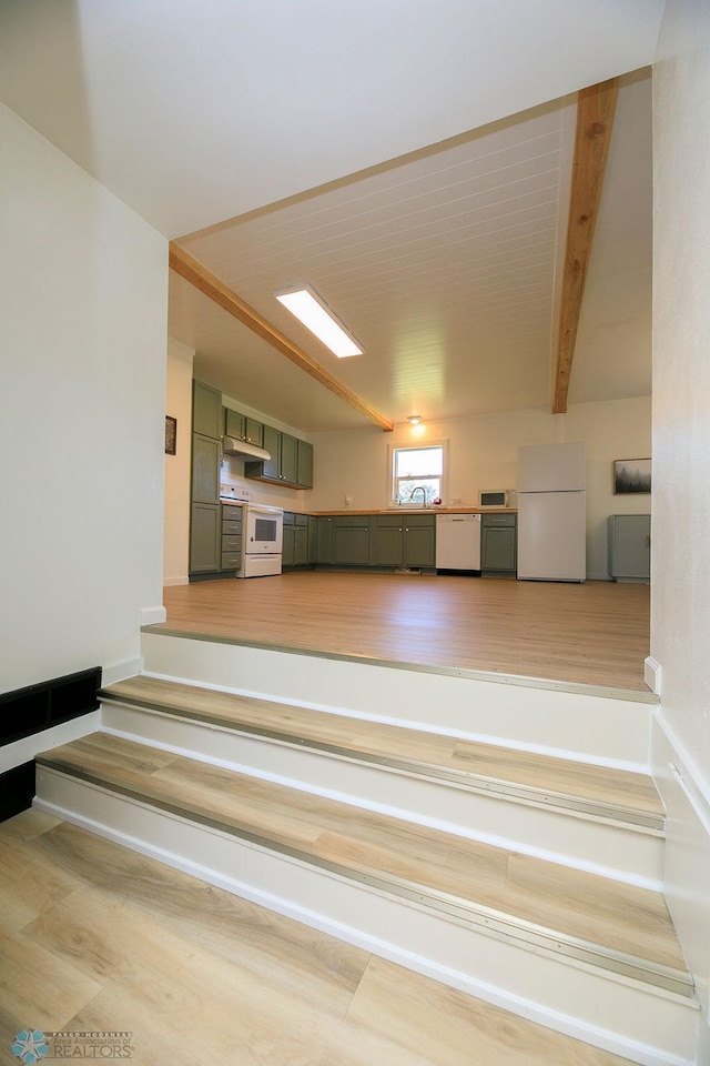 interior space with beam ceiling, hardwood / wood-style flooring, and sink