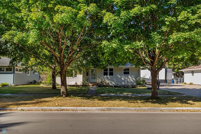 obstructed view of property with a front lawn