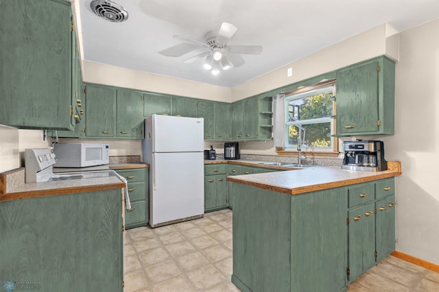 kitchen with ceiling fan, white appliances, green cabinetry, sink, and kitchen peninsula