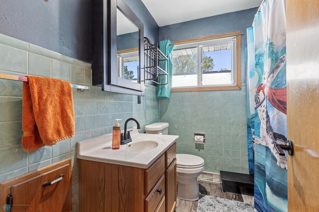 bathroom featuring vanity, hardwood / wood-style flooring, walk in shower, tile walls, and toilet