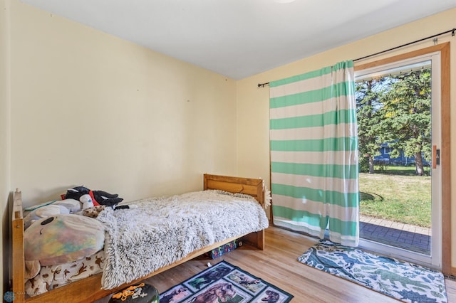 bedroom with access to exterior and hardwood / wood-style floors