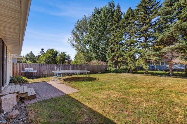 view of yard featuring a trampoline and a patio area