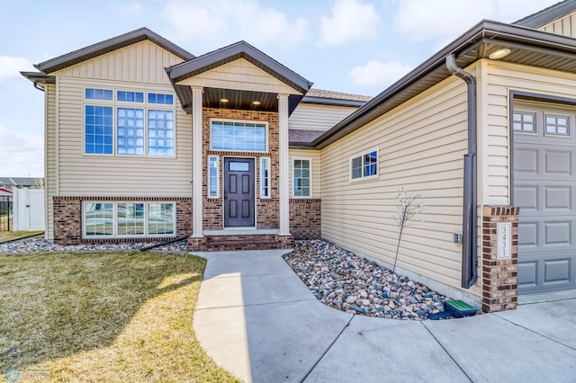 view of exterior entry featuring a garage and a yard