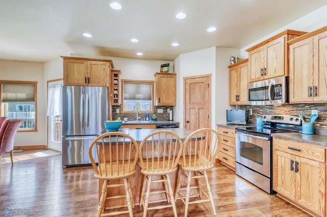 kitchen featuring decorative backsplash, stainless steel appliances, and light hardwood / wood-style floors