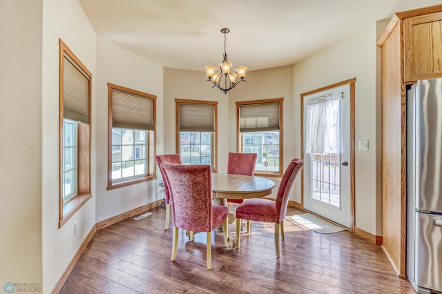 dining space featuring an inviting chandelier and dark wood-type flooring