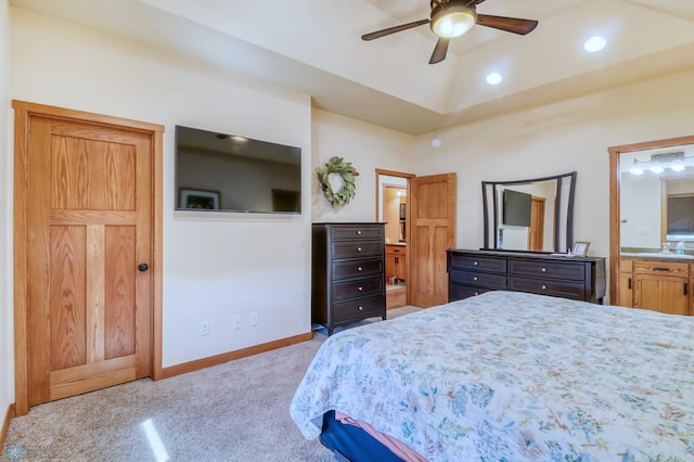 carpeted bedroom featuring ensuite bath, ceiling fan, and sink