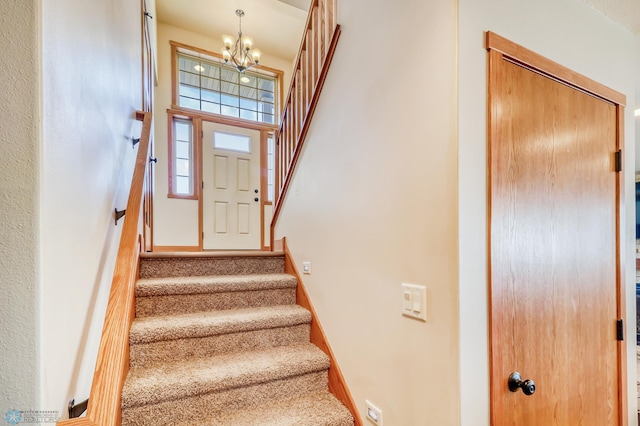 stairs featuring a high ceiling and a chandelier